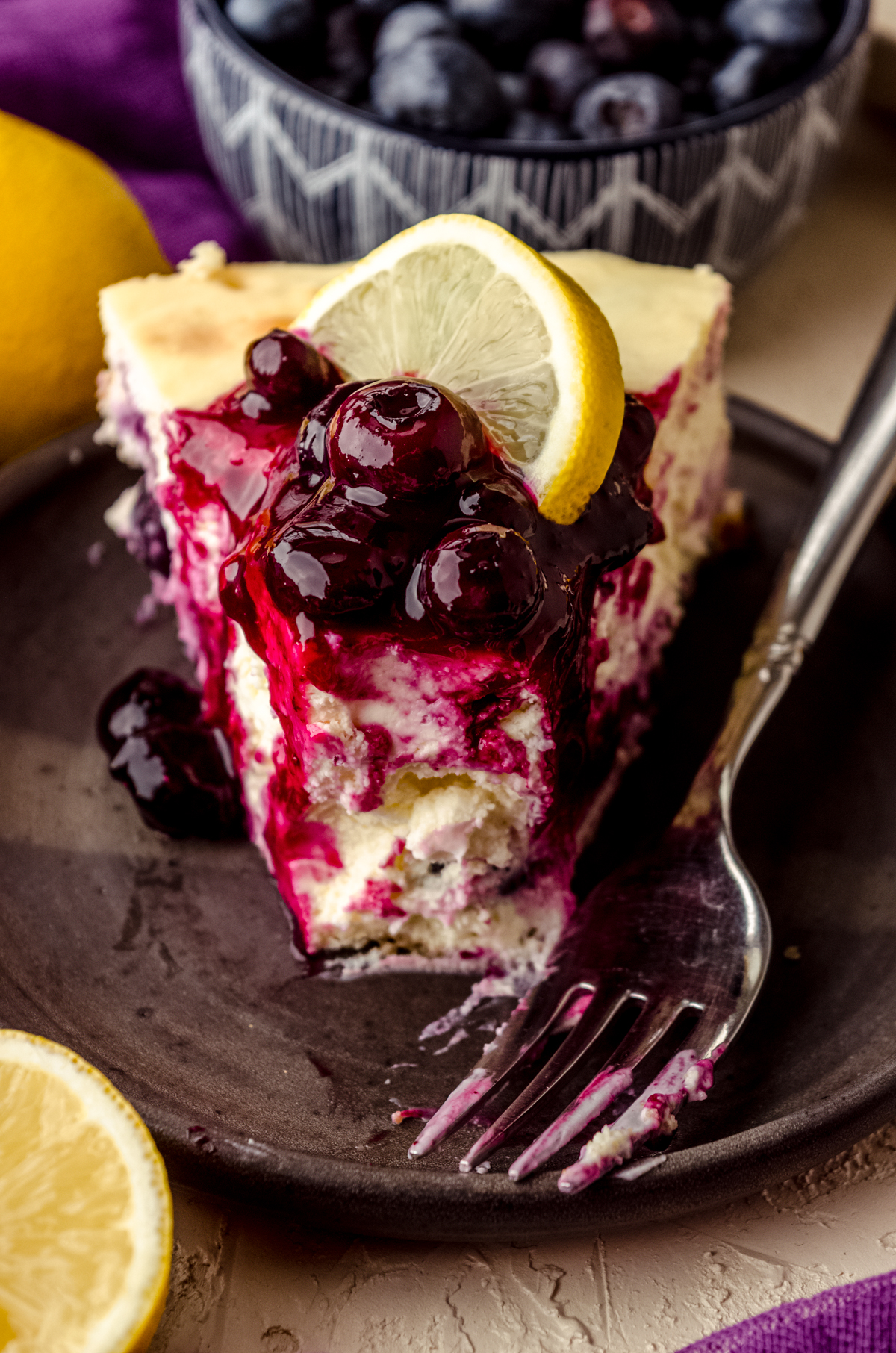 A slice of lemon blueberry cheesecake on a plate.