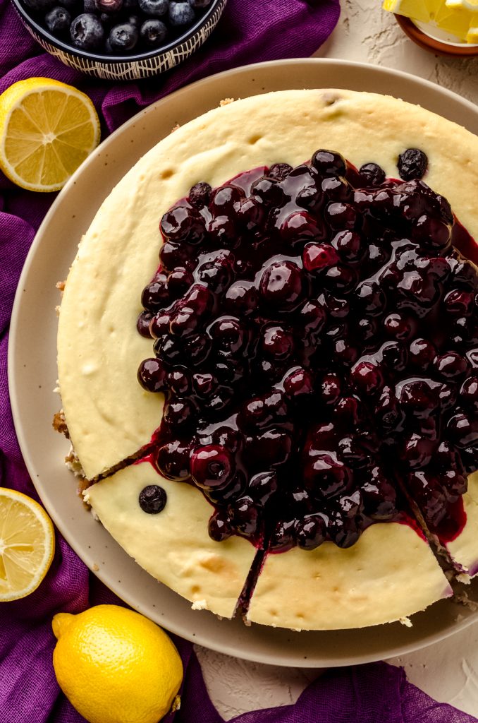 Aerial photo of a blueberry lemon cheesecake that has been sliced.