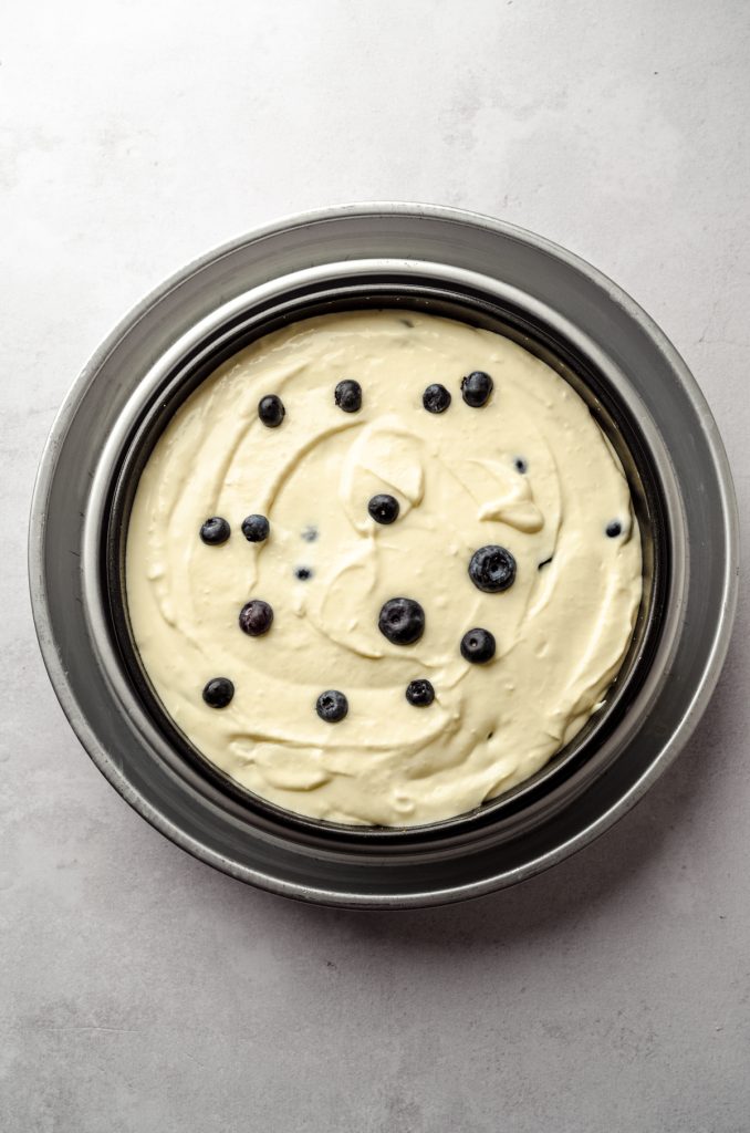 Aerial photo of lemon blueberry cheesecake batter in a springform pan ready to bake.