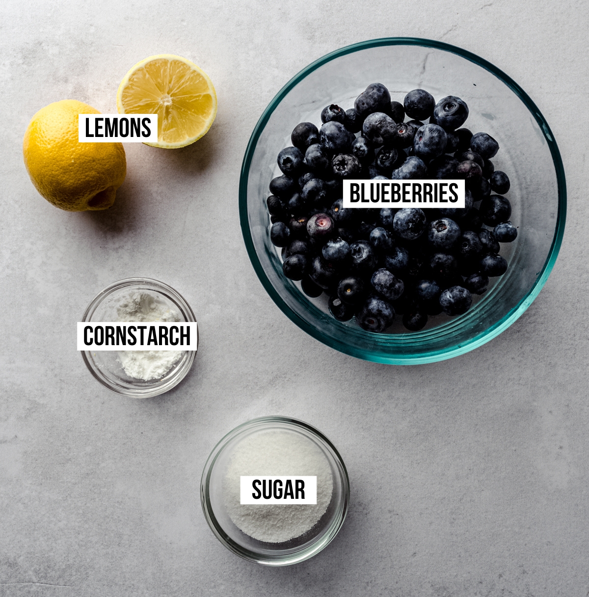 Aerial photo of ingredients for blueberry sauce with text overlay labeling each ingredient.