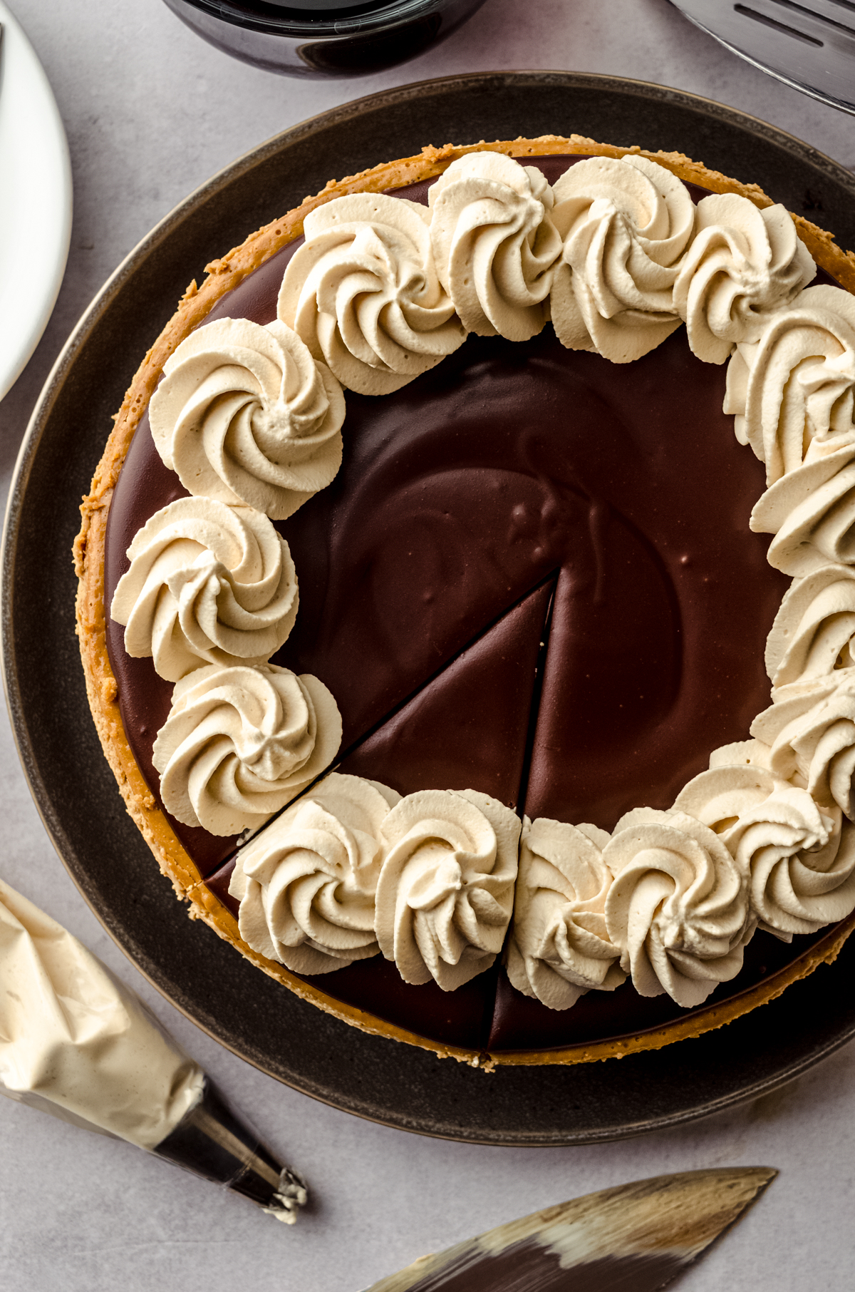A coffee cheesecake with ganache and coffee whipped cream on top of it.