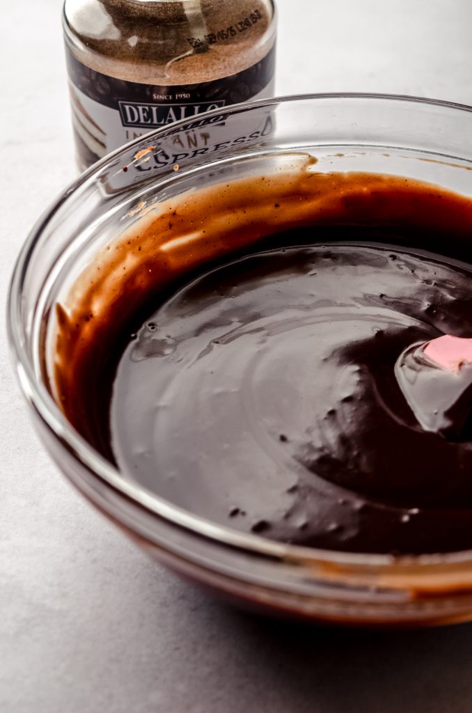 A bowl of espresso chocolate ganache with a spatula in it.