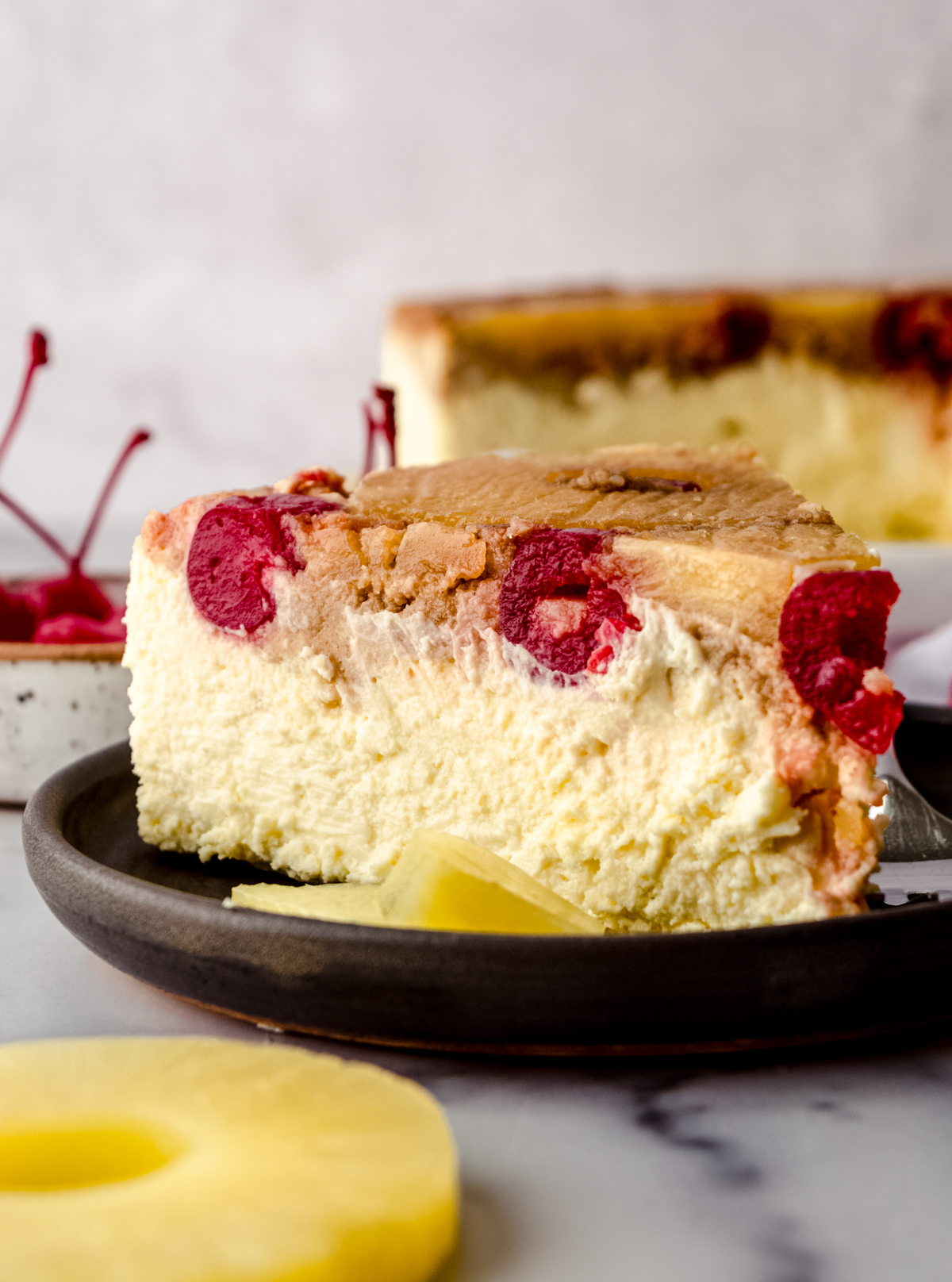 A slice of pineapple upside down cheesecake sitting on a plate.