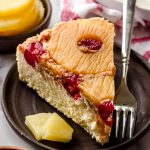 A slice of pineapple upside down cheesecake sitting on a plate with a fork.