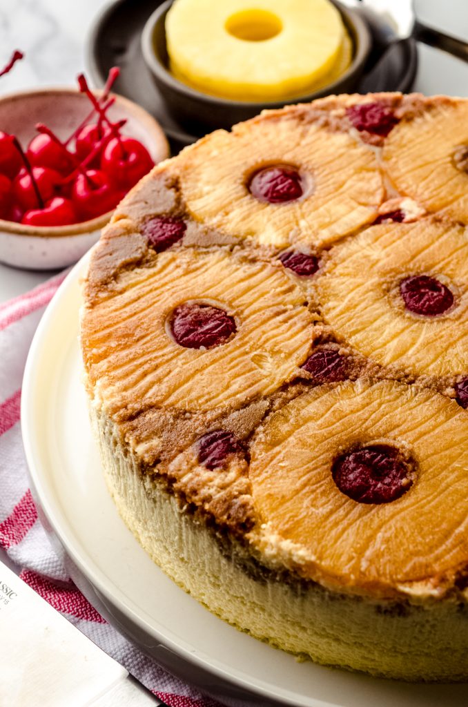 A pineapple upside down cheesecake sitting on a platter.