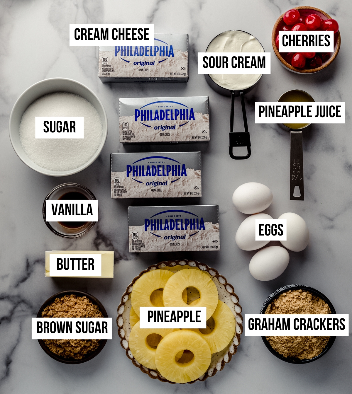 Aerial photo of ingredients to make pineapple upside down cheesecake with text overlay labeling each ingredient.