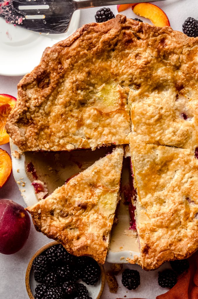 Aerial photo of a blackberry peach pie that has been sliced.