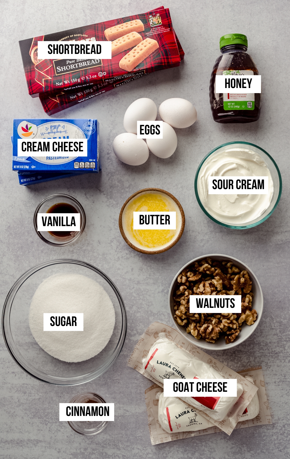 Aerial photo of ingredients to make goat cheese cheesecake with text overlay labeling each ingredient.