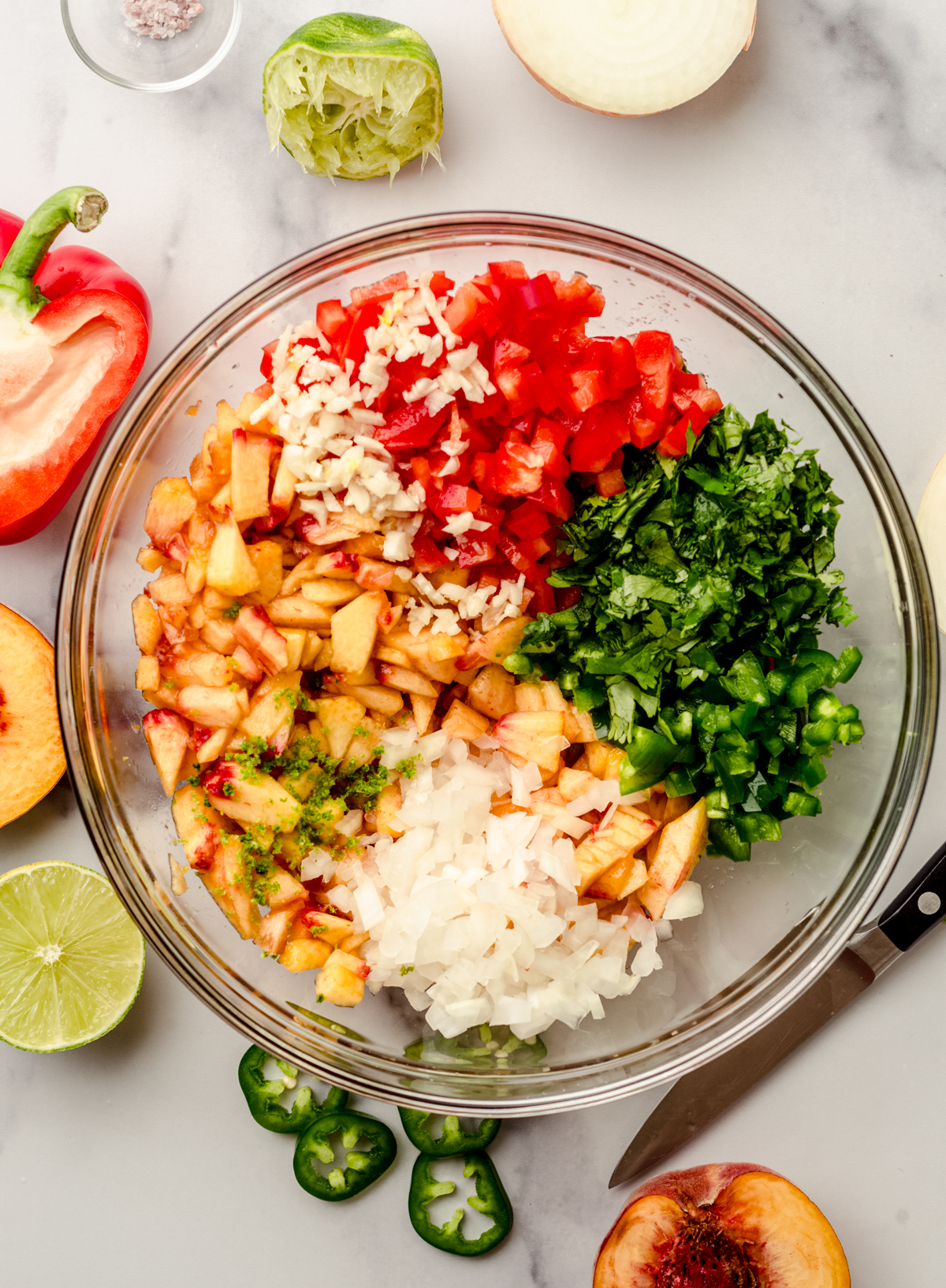 Aerial photo of a bowl of ingredients to make peach salsa.