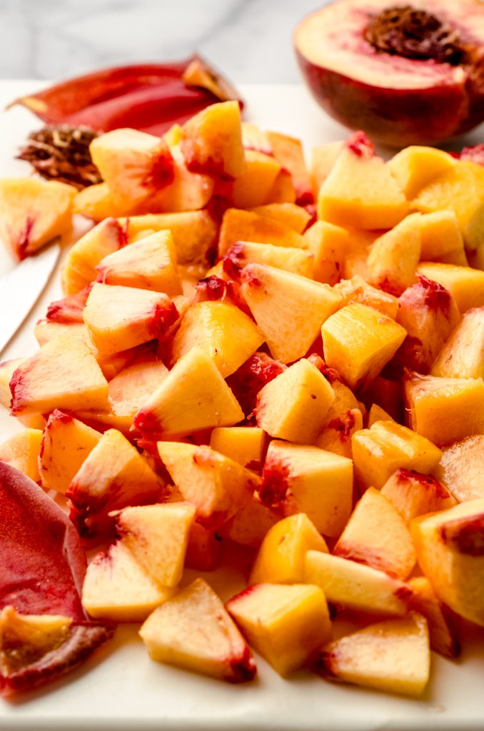 Chopped peaches on a cutting board.