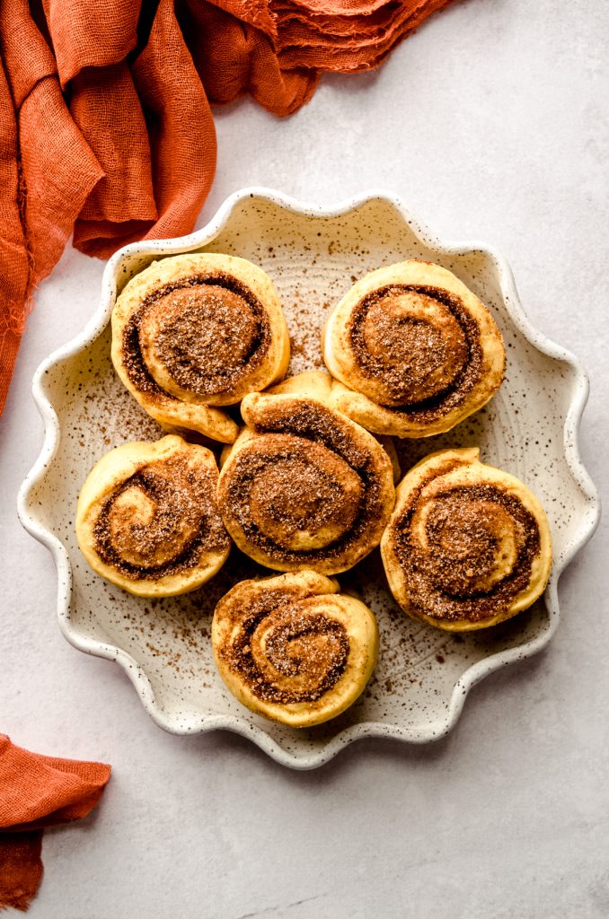 Pumpkin cinnamon rolls in a baking dish before rising.