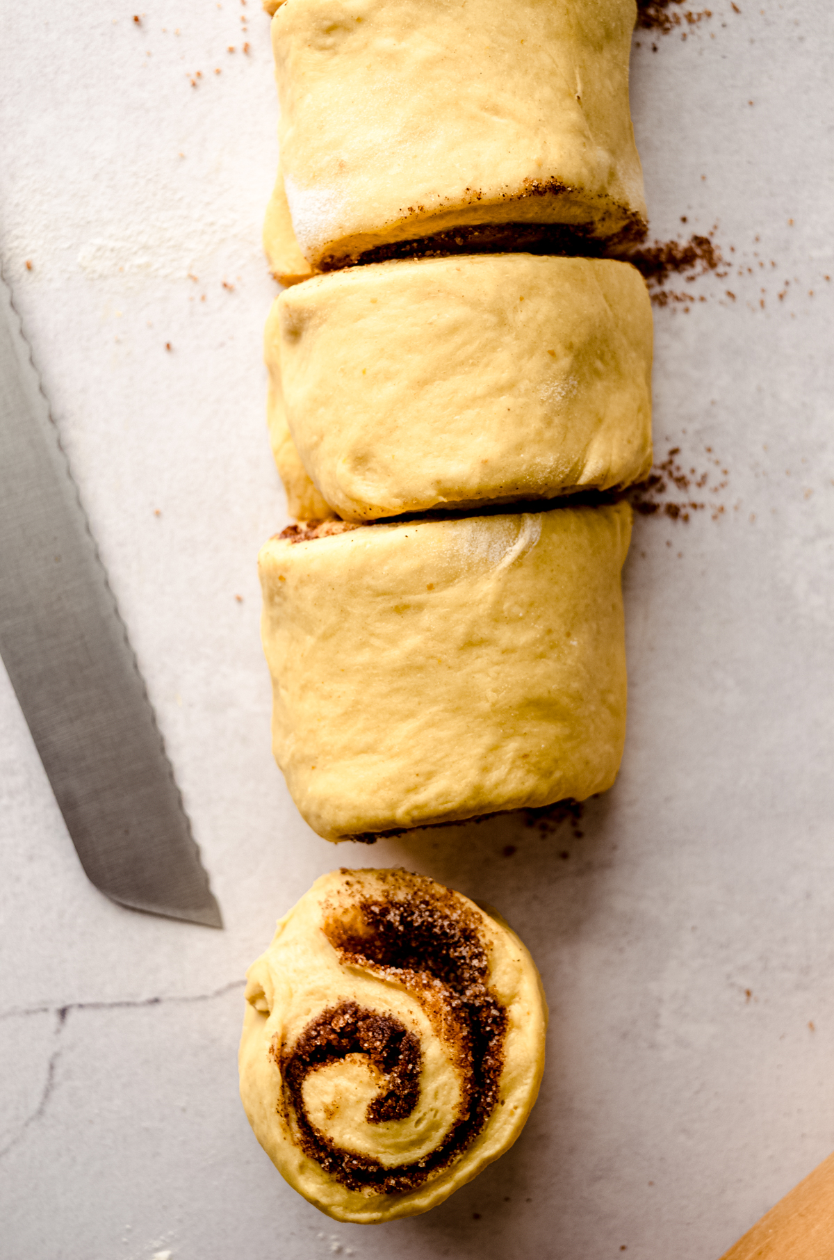 Aerial photo of a log of pumpkin cinnamon rolls that have been sliced.