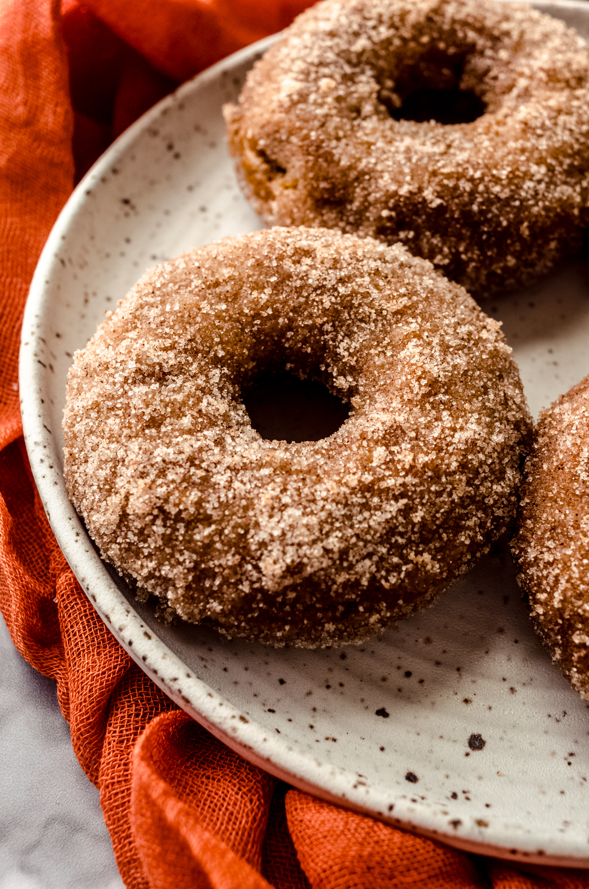 A baked pumpkin donut on a plate.