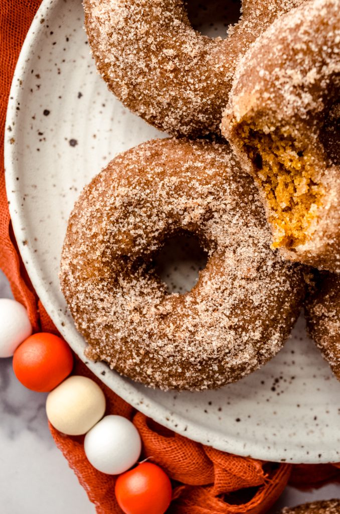 Aerial photo of a baked pumpkin donut on a plate.