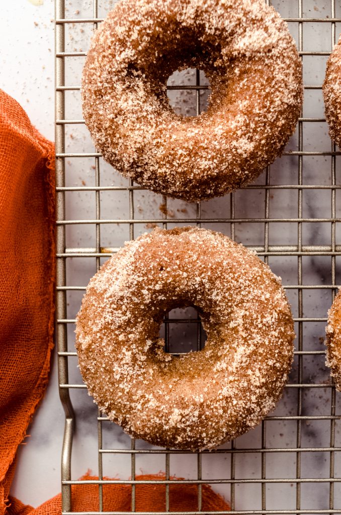 Baked pumpkin donuts on a wire cooling rack.