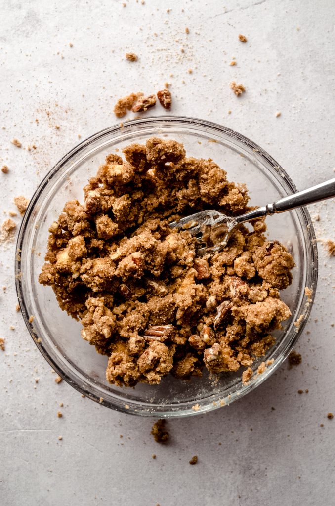 Aerial photo of a bowl of pecan streusel topping with a fork in it.