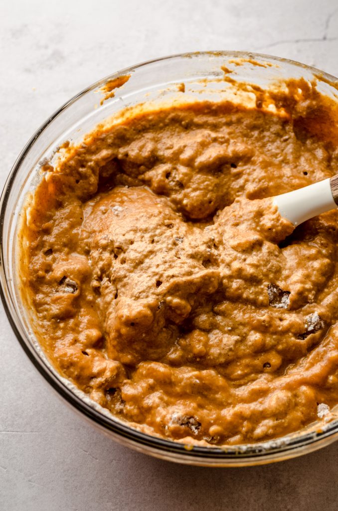 The batter for pumpkin pancakes in a bowl with a spatula.