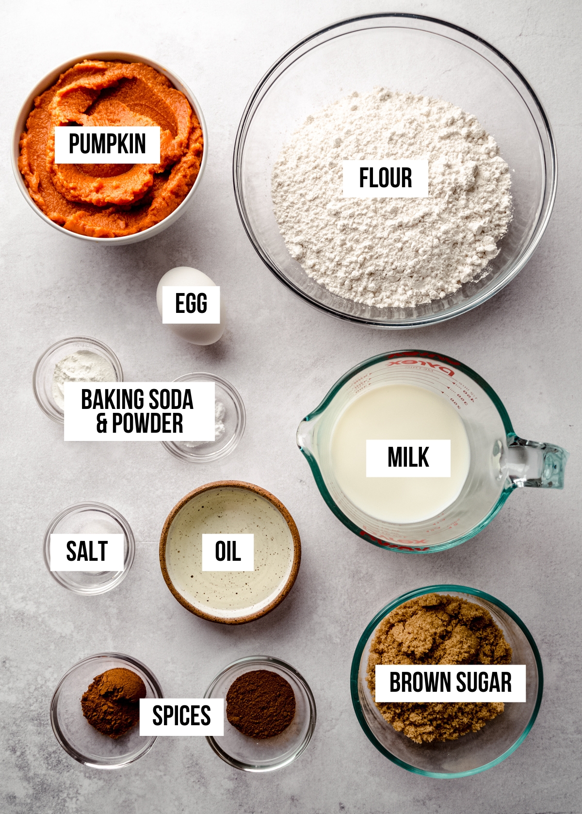 Aerial photo of ingredients to make pumpkin pancakes with text overlay labeling each ingredient.