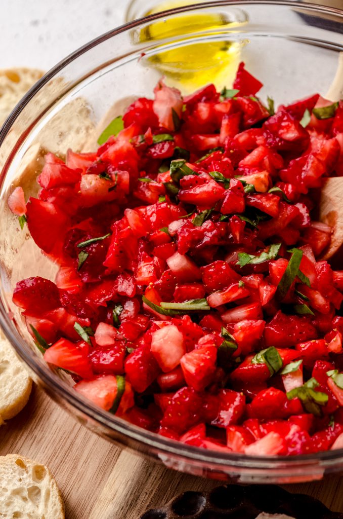 A bowl of strawberries and basil to make strawberry bruschetta.