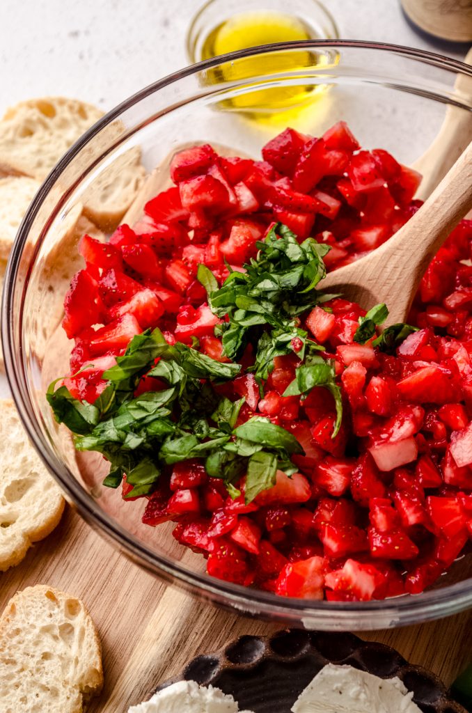 A bowl of strawberries and basil to make strawberry bruschetta.