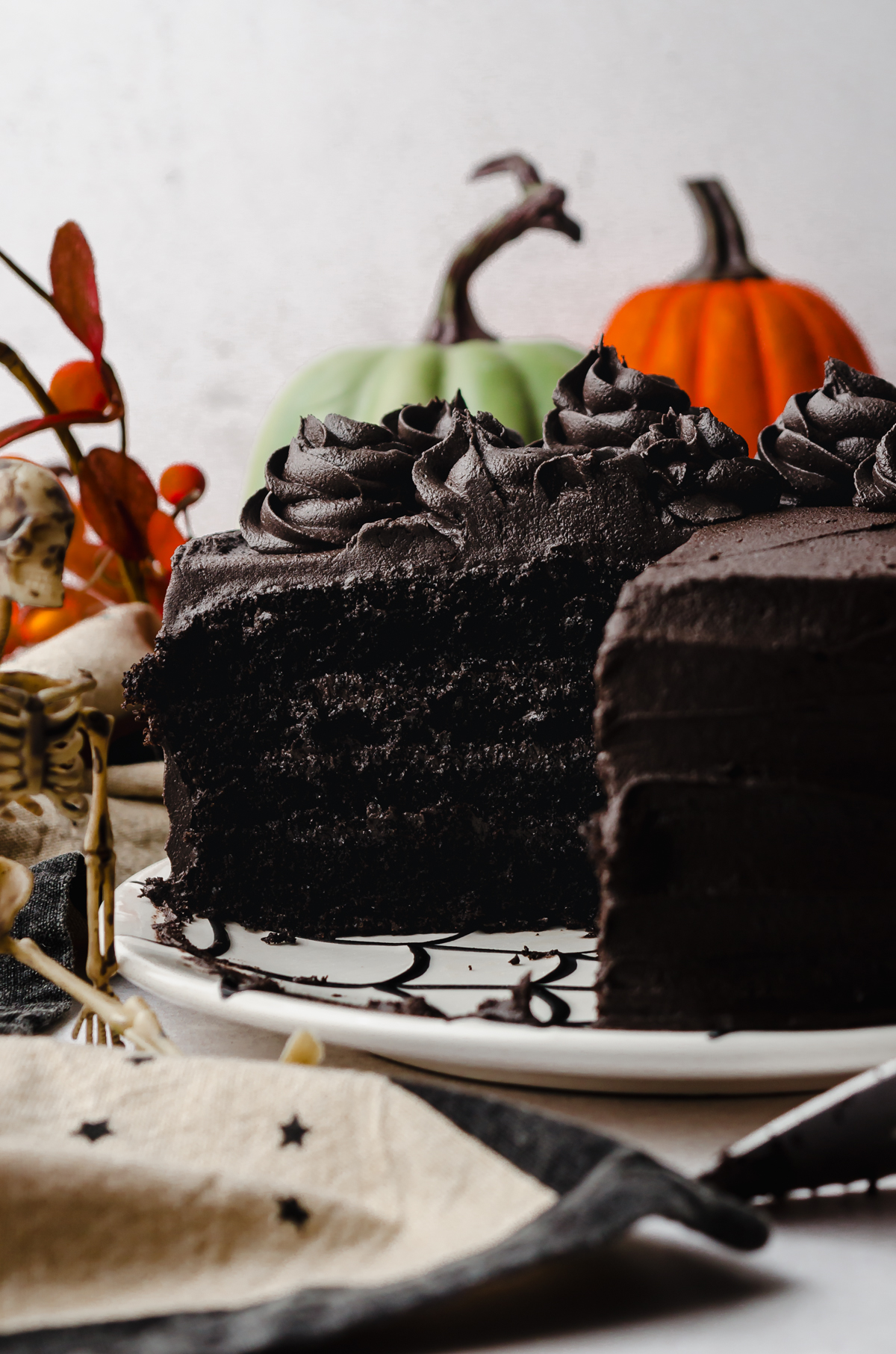 A black cocoa chocolate cake that has been cut so you can see the cross section sitting on a plate.