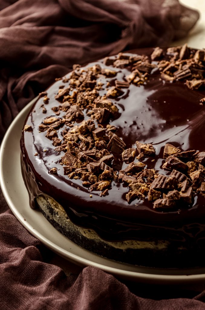 A chocolate peanut butter cheesecake on a plate.