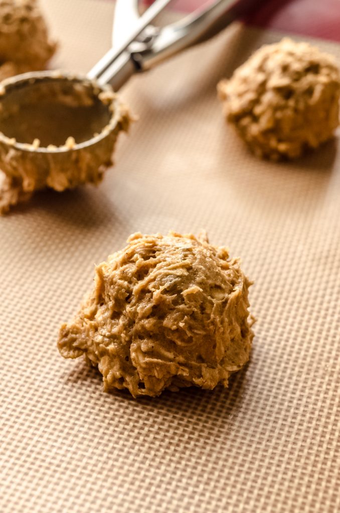 Chewy oatmeal cookie dough ball on a baking sheet.