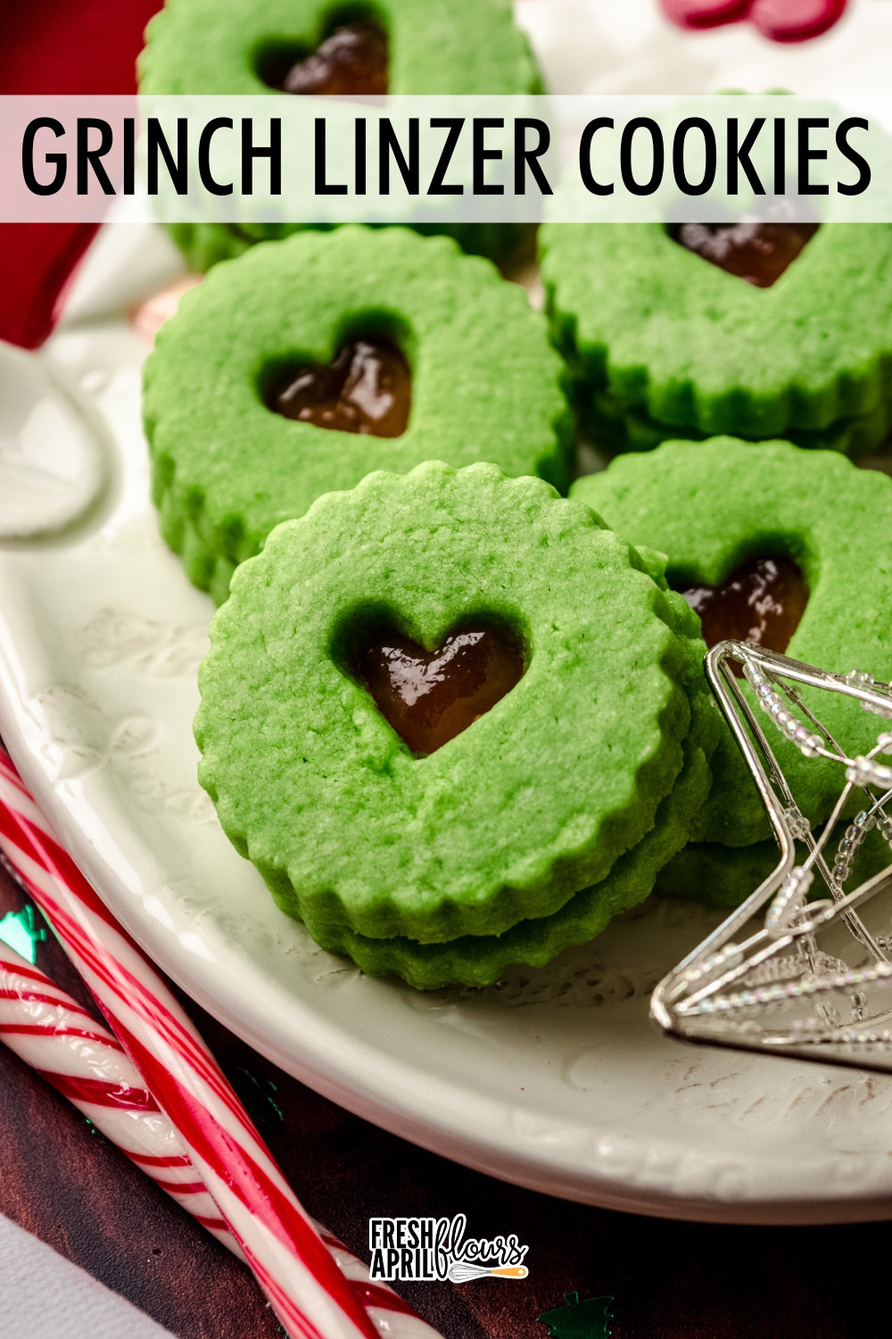 Turn your traditional Linzer cookies into a charming holiday version with these Grinch cookies that feature tender and buttery almond flour sandwich cookies filled with strawberry jam. These cookies are the perfect pop of color on cookie trays or in the spread for a Grinch themed party! via @frshaprilflours