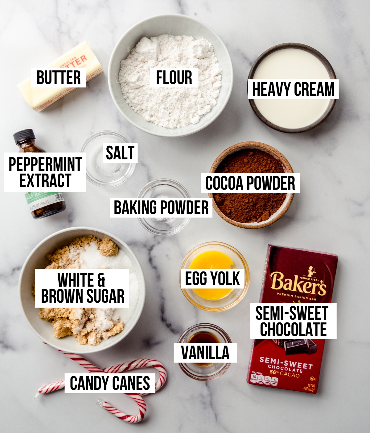 Aerial photo of ingredients to make chocolate peppermint thumbprints with text overlay labeling each ingredient. 