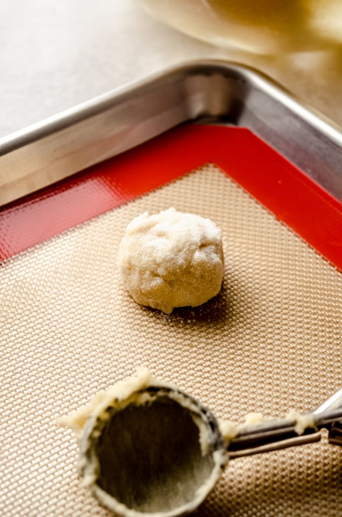 A ball of cream cheese sugar cookie dough on a baking sheet.