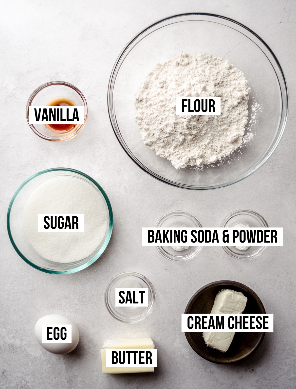 Aerial photo of ingredients to make cream cheese sugar cookies with text overlay labeling each ingredient.