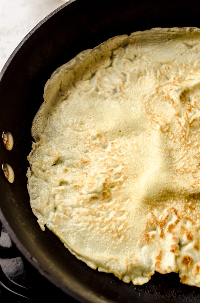 A homemade crepe in a skillet.