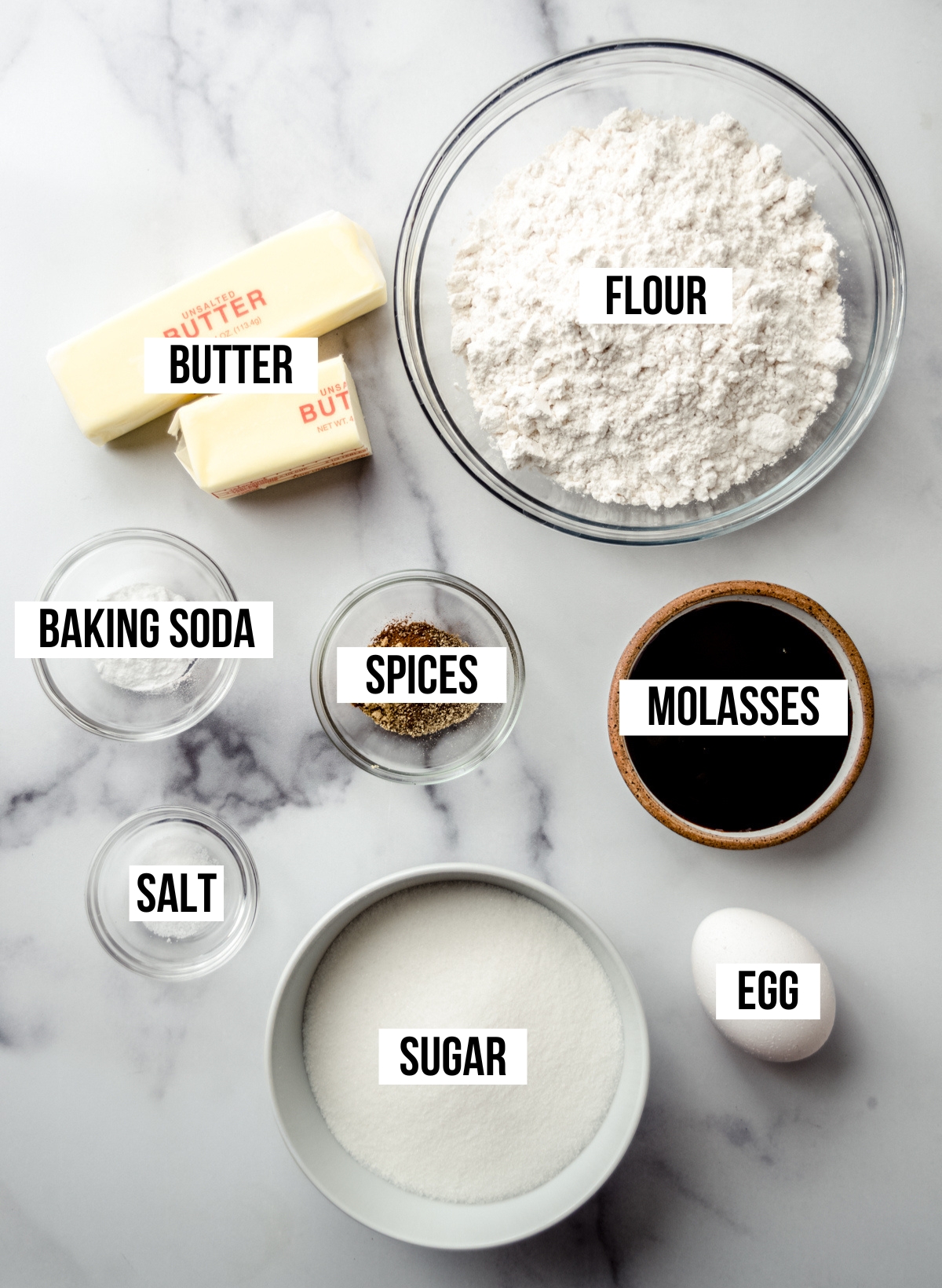 Aerial photo of ingredients to make gingerbread sandwich cookies with text overlay labeling each ingredient.