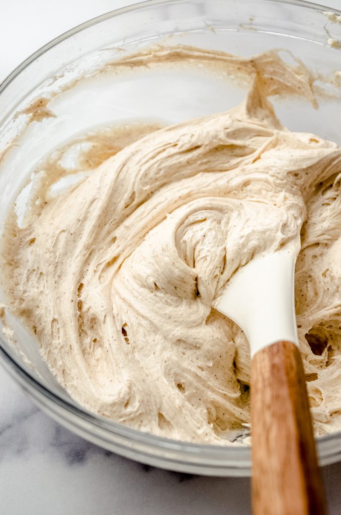 A bowl of cinnamon spiced marshmallow buttercream frosting to fill gingerbread sandwich cookies.