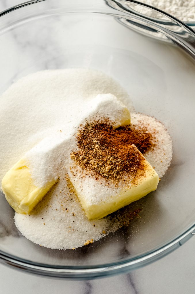 Butter, spices, and sugar in a bowl ready to be creamed together to make cookies.