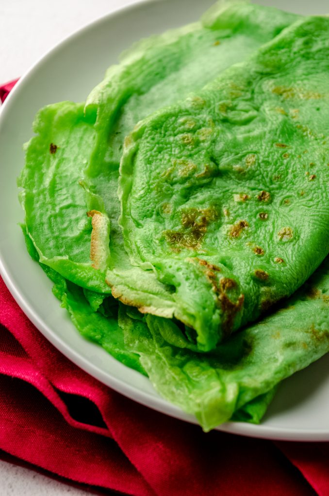 A plate of green crepes that will be used to make Grinch crepes.