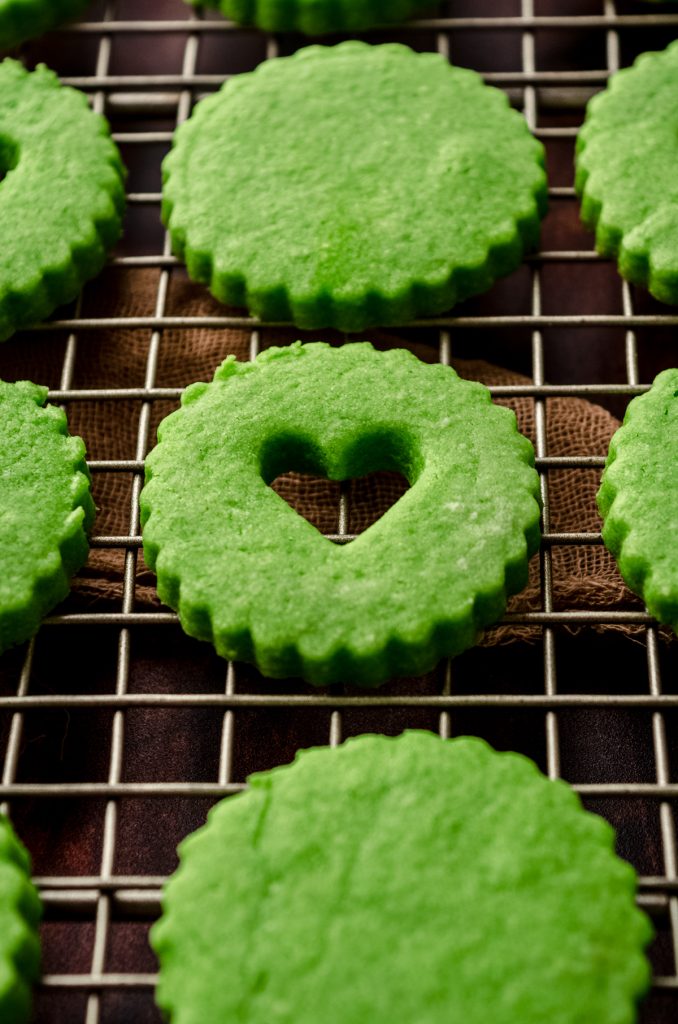 Grinch Linzer cookies on a cooling rack.