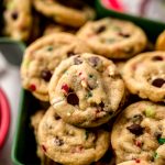 Mini Christmas chocolate chip cookies with festive sprinkles in it sitting in a tree shaped bowl.