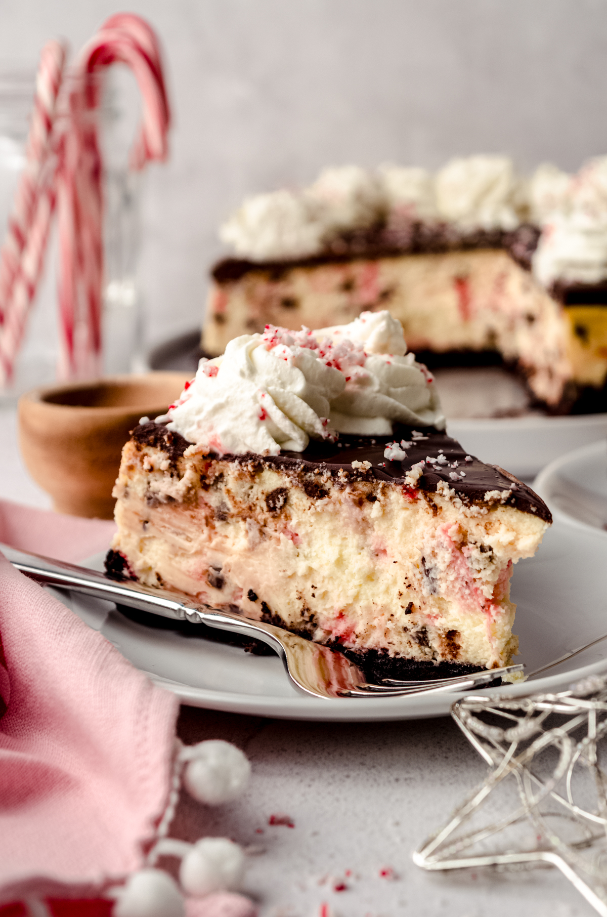 A slice of peppermint bark cheesecake on a plate with a fork.