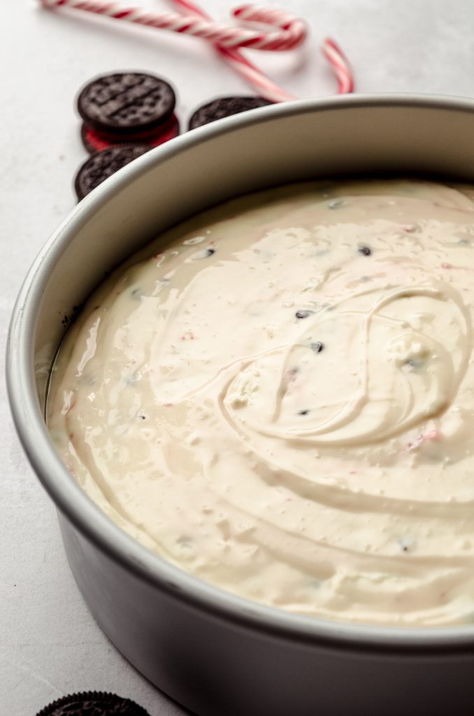 A peppermint bark cheesecake in a baking pan.