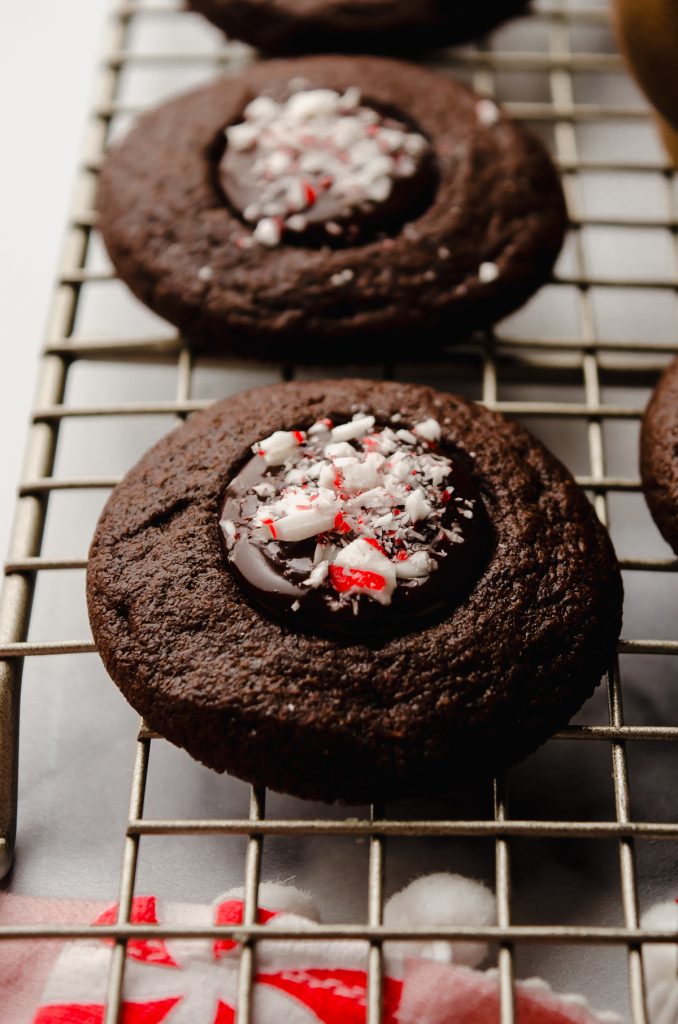 Chocolate peppermint thumbprints on a cooling rack.