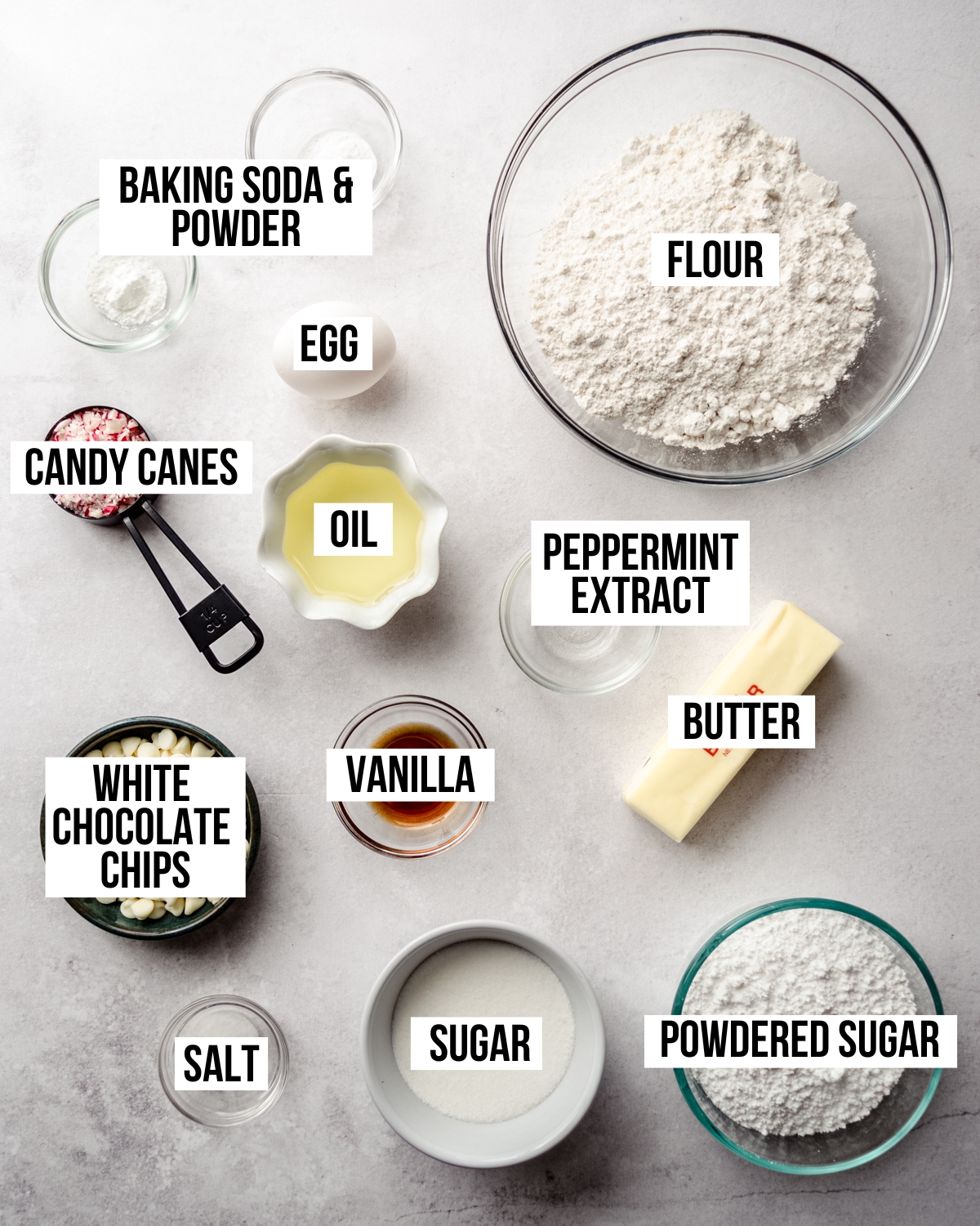 Aerial photo of ingredients to make white chocolate peppermint cookies with text overlay labeling each ingredient.