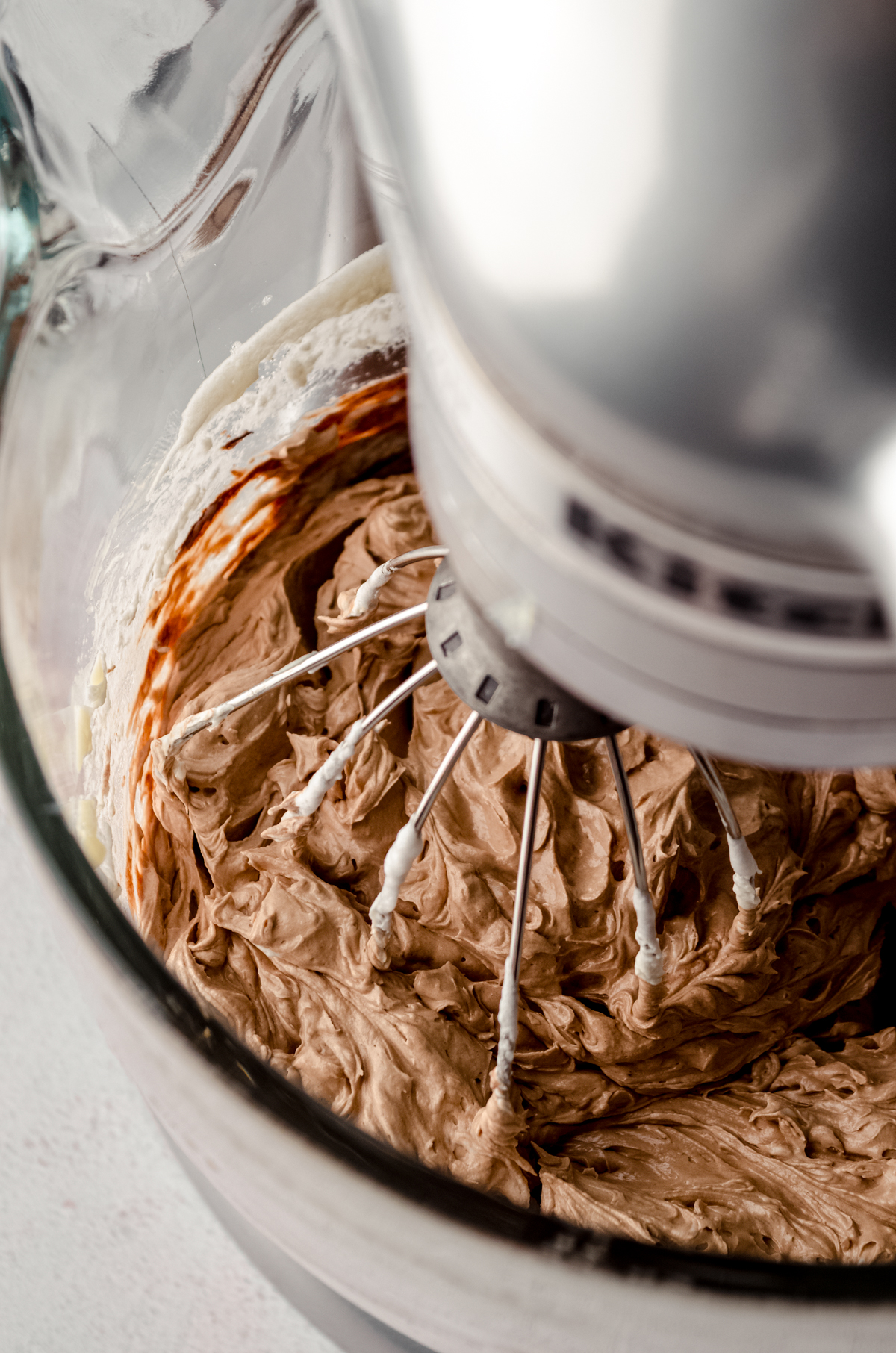 Swiss meringue buttercream in the bowl of a stand mixer fitted with the whisk attachment.