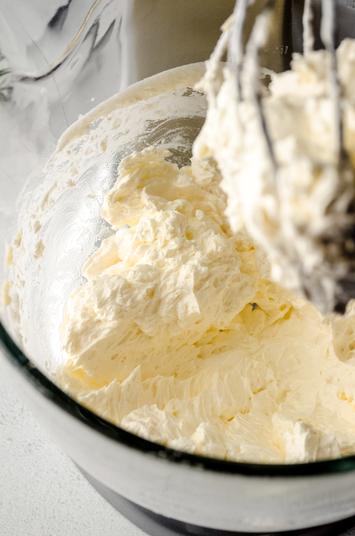 Swiss meringue buttercream in the bowl of a stand mixer fitted with the whisk attachment.