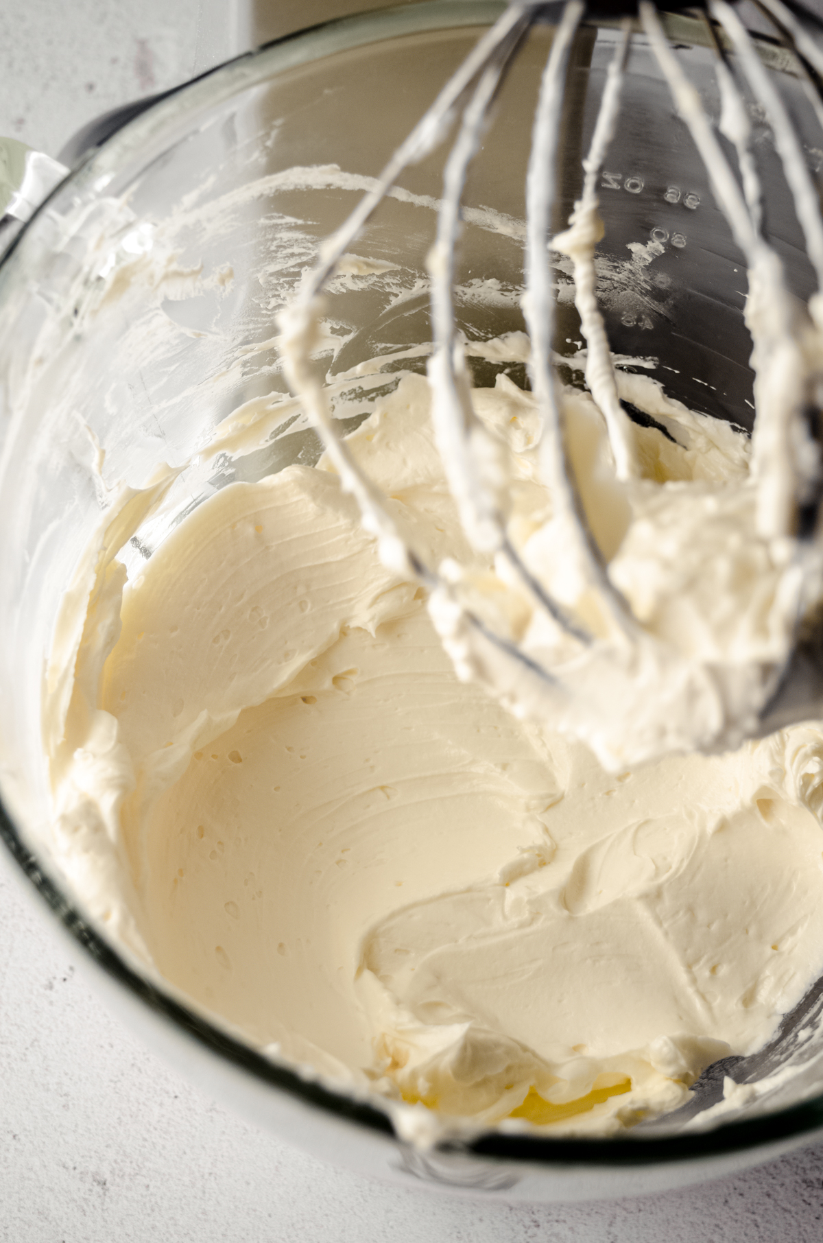 Swiss meringue buttercream in the bowl of a stand mixer fitted with the whisk attachment.