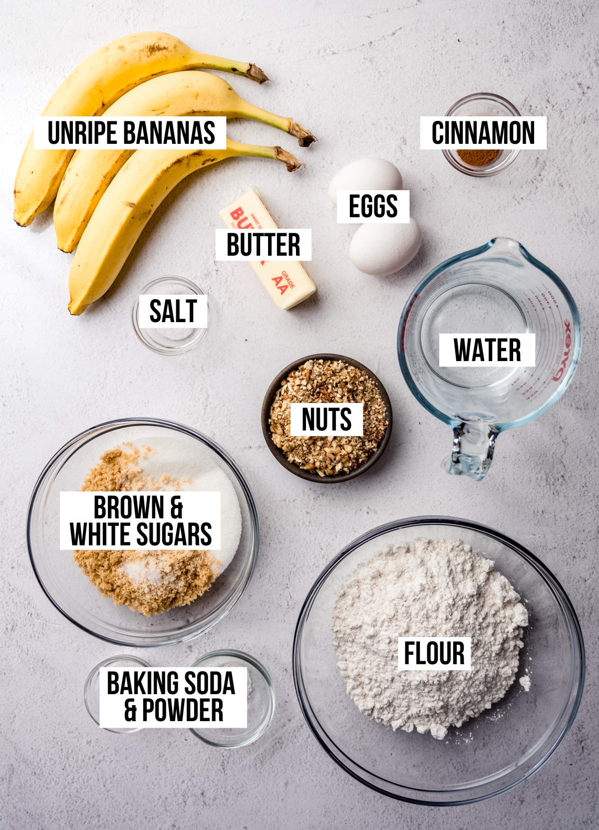 Aerial photo of ingredients to make banana bread with unripe bananas with text overlay labeling each ingredient.