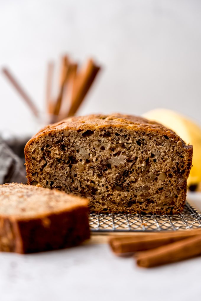 A photo of a loaf of banana bread made with unripe bananas on a cooling rack.