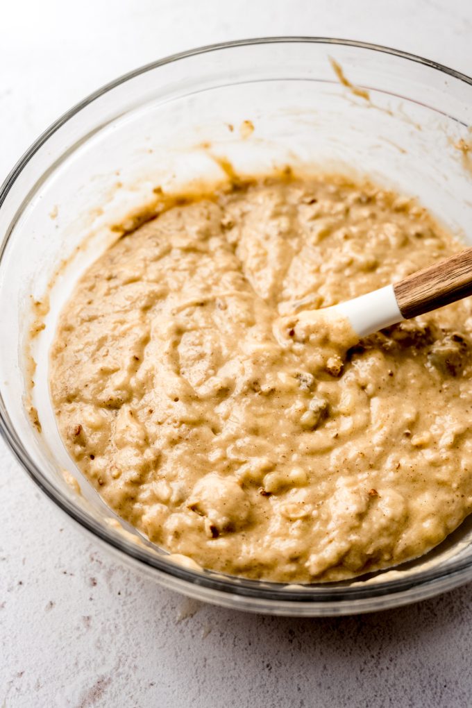 Banana bread batter in a bowl with a spatula.