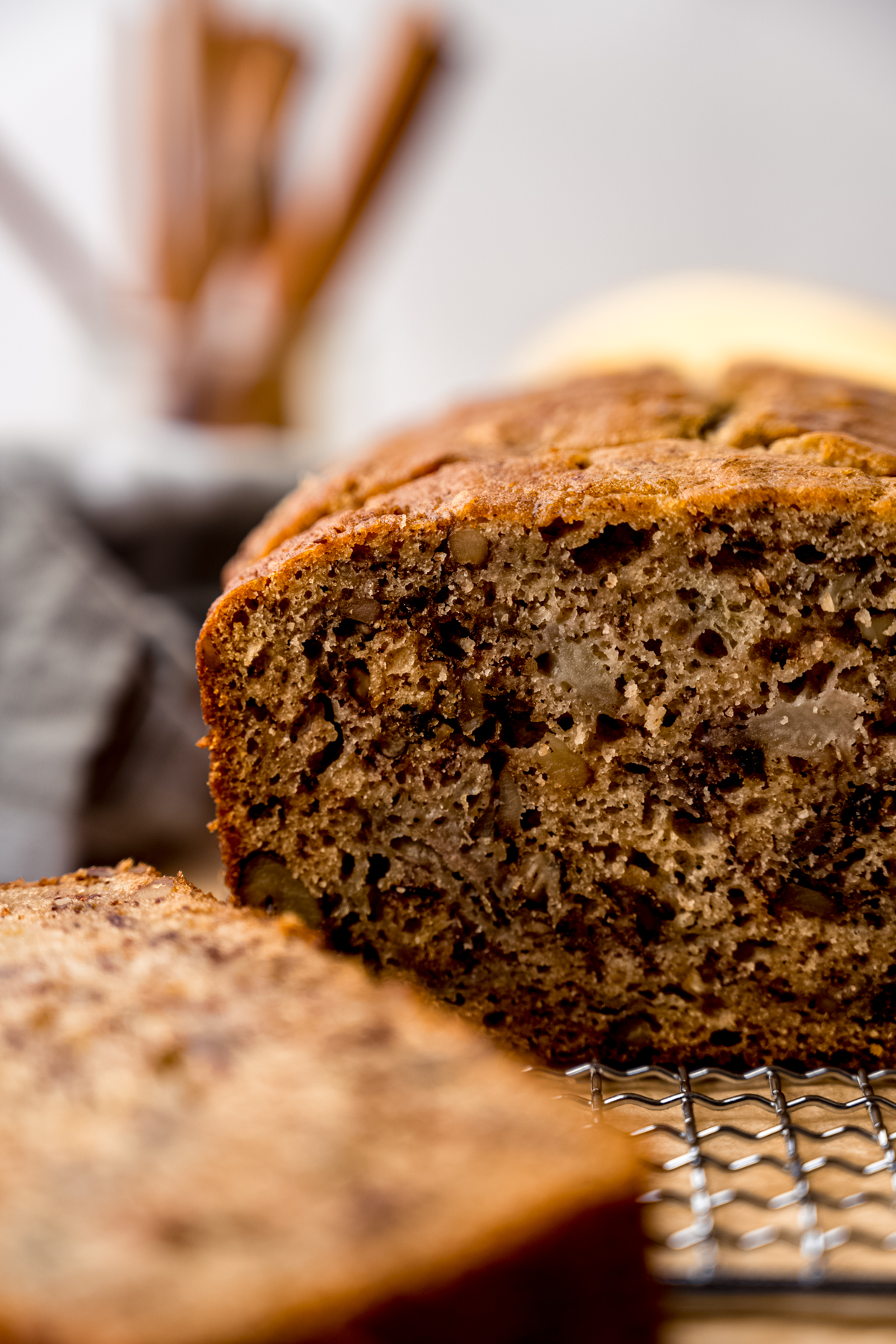 A photo of a loaf of banana bread made with unripe bananas on a cooling rack.