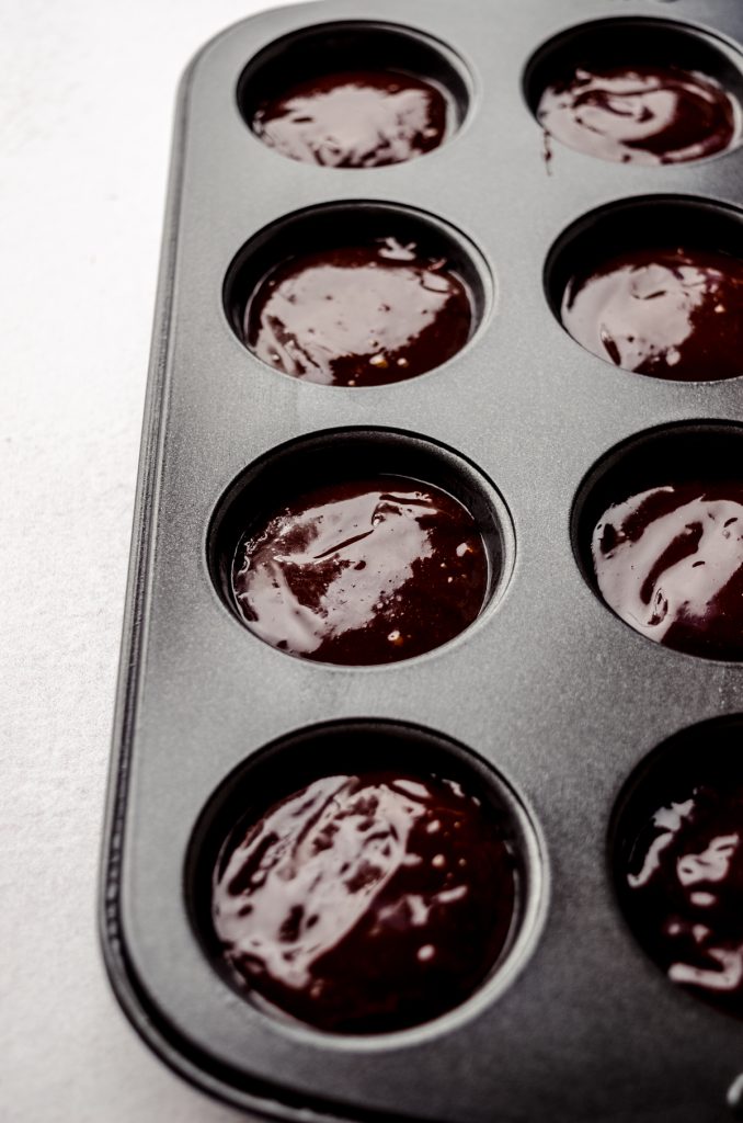 Brownie batter in a mini muffin tin before baking.